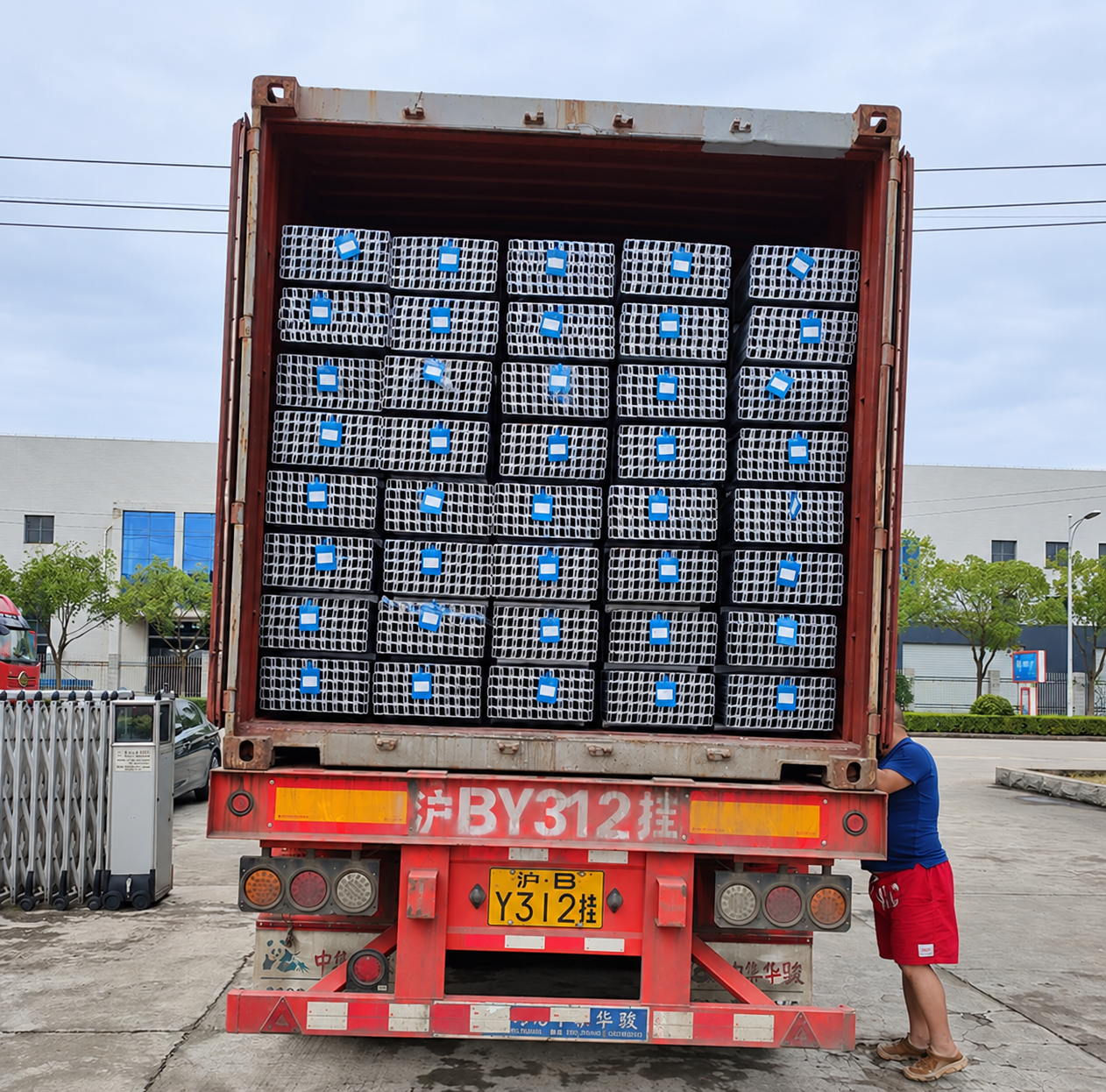 Open shipping container loaded with protected metal products at a factory